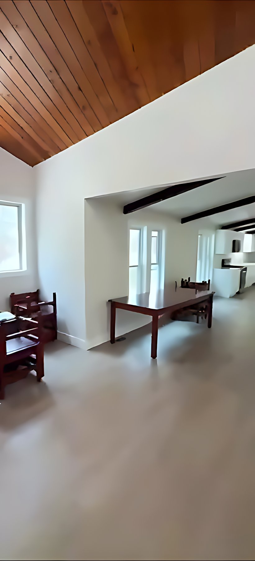 Remodeled living area beneath a vaulted wood ceiling