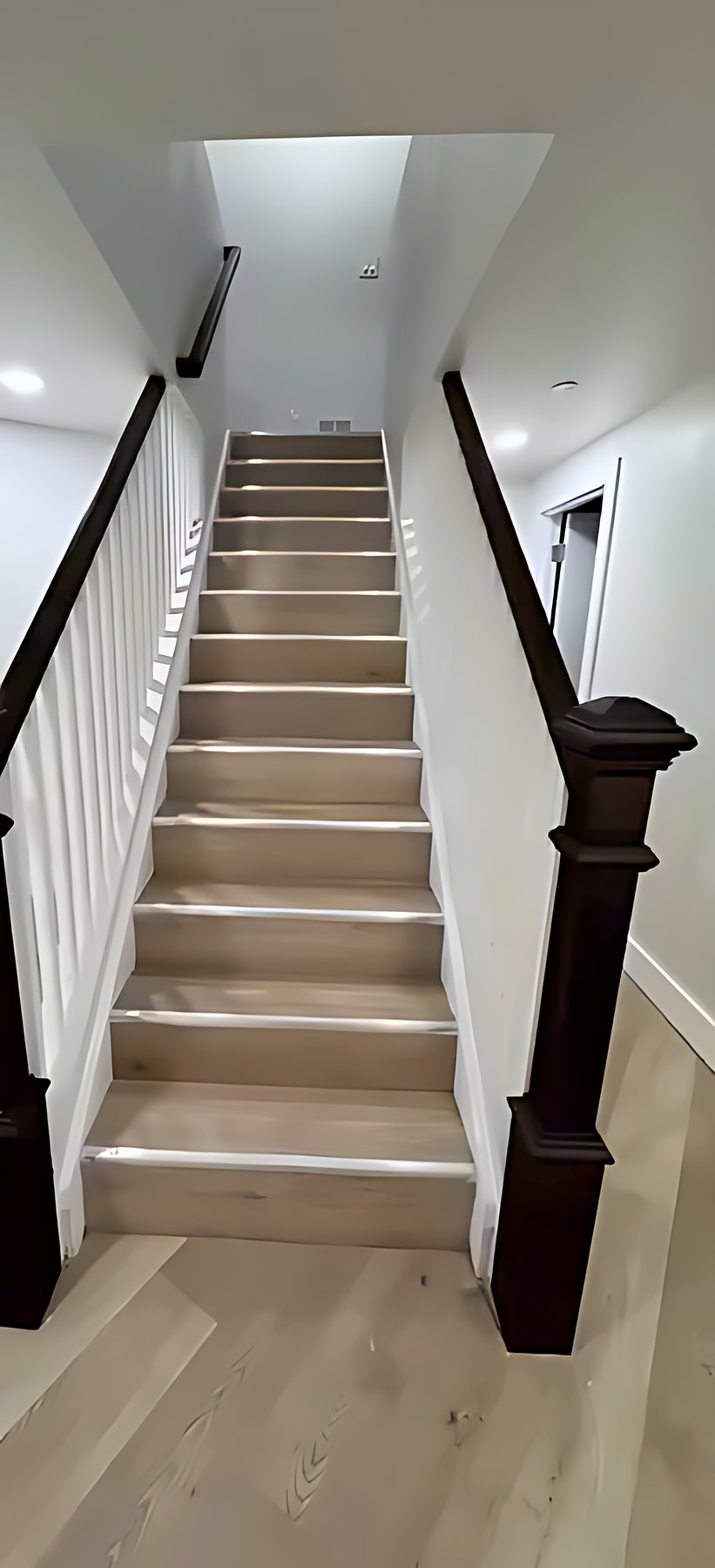White staircase with a dark handrail